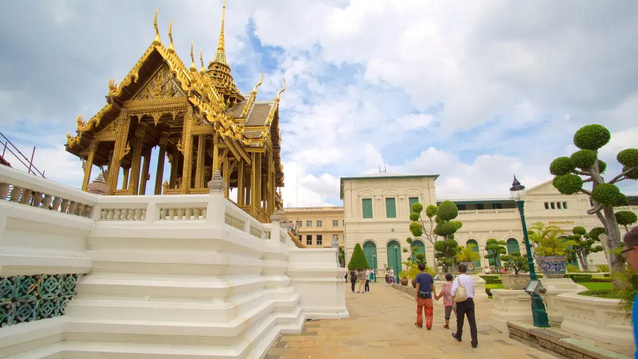 Gyllene tempel vid Grand Palace, med bes&ouml;kare som promenerar p&aring; stenlagd g&aring;ng.