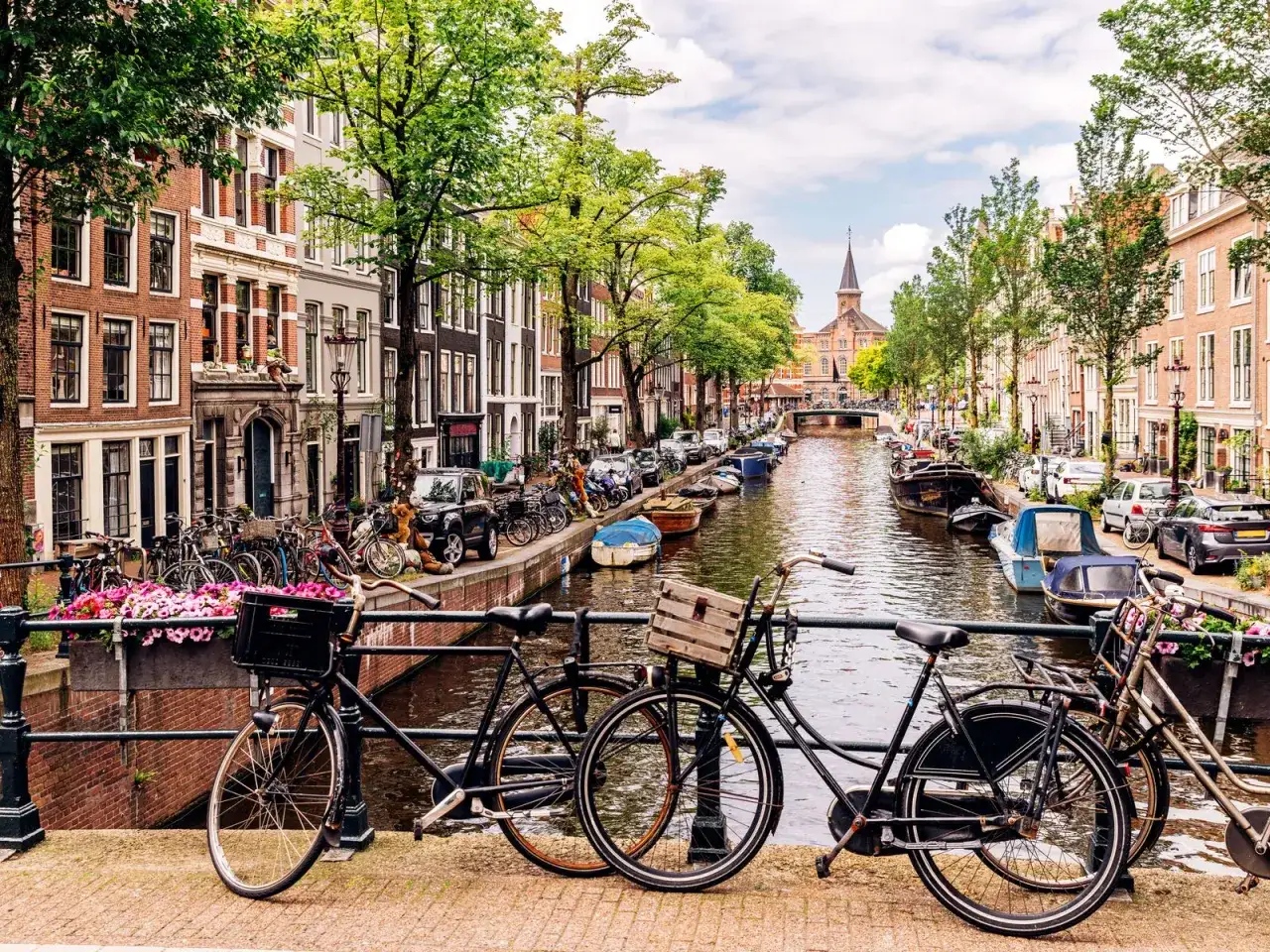 En klassisk Amsterdam-vy med kanaler, husb&aring;tar och cyklar. Perfekt f&ouml;r din amsterdam reseguide.
