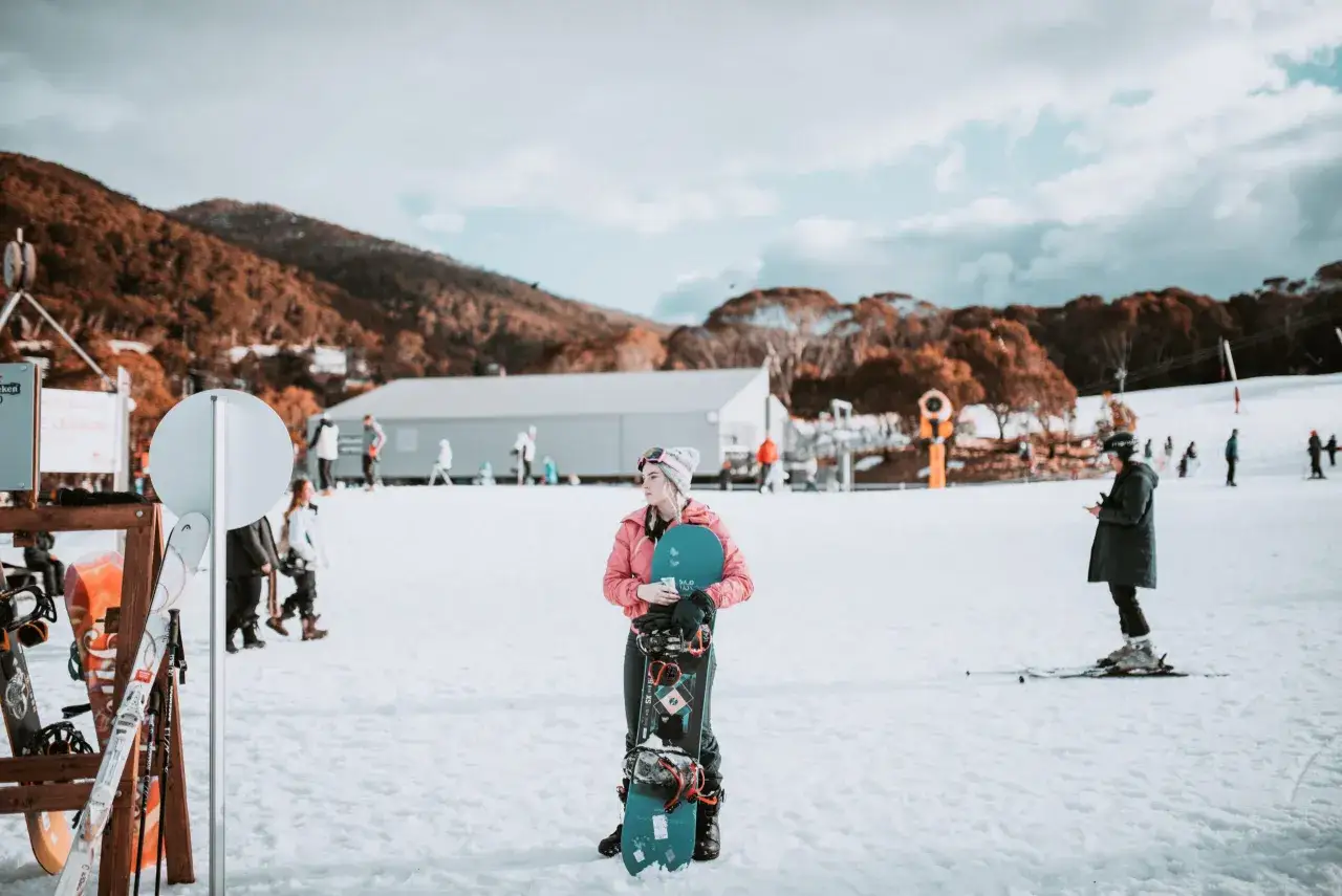 En ung kvinna med snowboard i en sn&ouml;ig milj&ouml;, en p&aring;minnelse om att det faktiskt finns vinter i Australien.