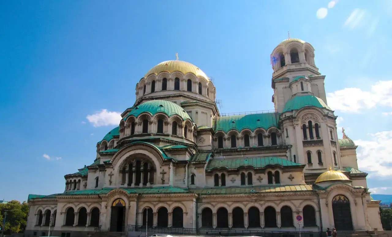 Alexander Nevsky-katedralen i Sofia, Bulgarien, med sina gyllene och gröna kupoler mot en klarblå himmel.
