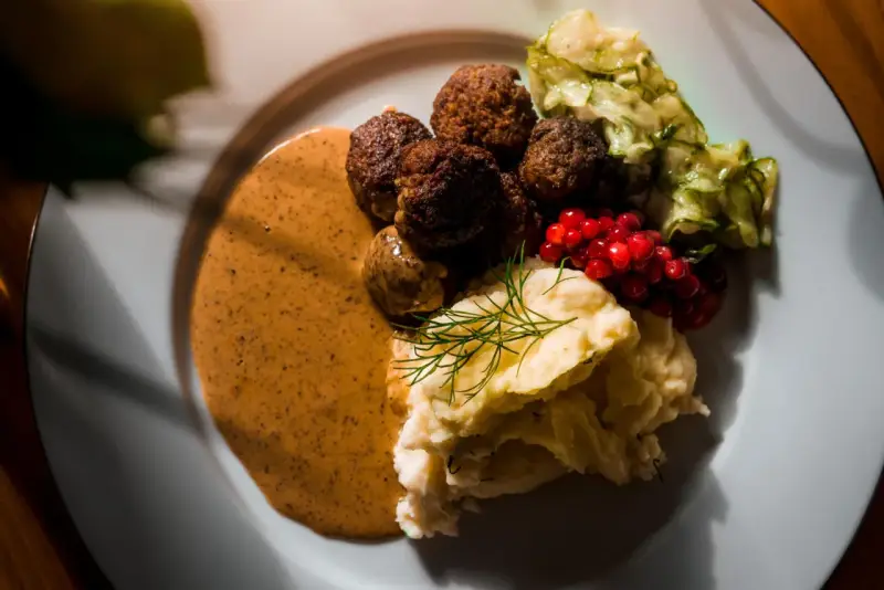 Klassiska svenska rätter: köttbullar med krämig sås, potatismos, lingon och pressgurka.